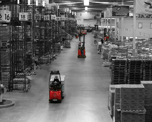 Black and white warehouse graphic with two Raymond red forklifts.