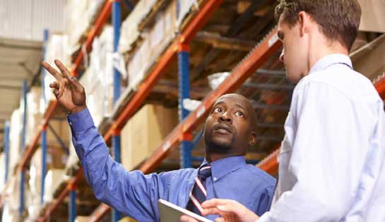 Warehouse managers discuss data insights from integrated reach truck technology to improve productivity