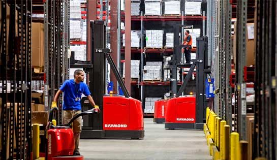 Two workers use rental lift trucks from Pengate in the warehouse